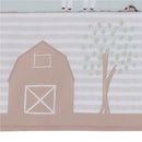 Nursery crib bedding set featuring a whimsical farmyard design with a barn, tree, and playful animal illustrations.