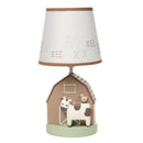 Decorative nursery lamp featuring a barn base with a cow and bird figurine, topped with a patterned shade.