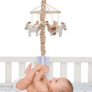 Musical baby crib mobile featuring plush farm animals, with a smiling baby reaching for them in a crib.
