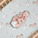 Sage green crib sheet with farm animal patterns featuring a smiling baby in a diaper, lying comfortably.