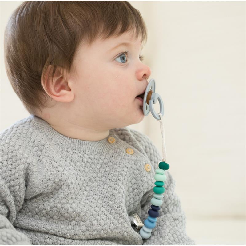 Boy with short hair using a Bella Tunno pacifier clip with colorful beads attached to a pacifier.