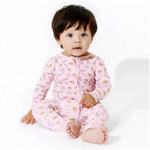 Bamboo convertible footie for infants featuring a pink milk and cookies pattern, worn by a seated baby.
