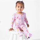 Convertible pink footie for toddlers featuring Harry Potter-themed prints, worn by a seated child on a stool.