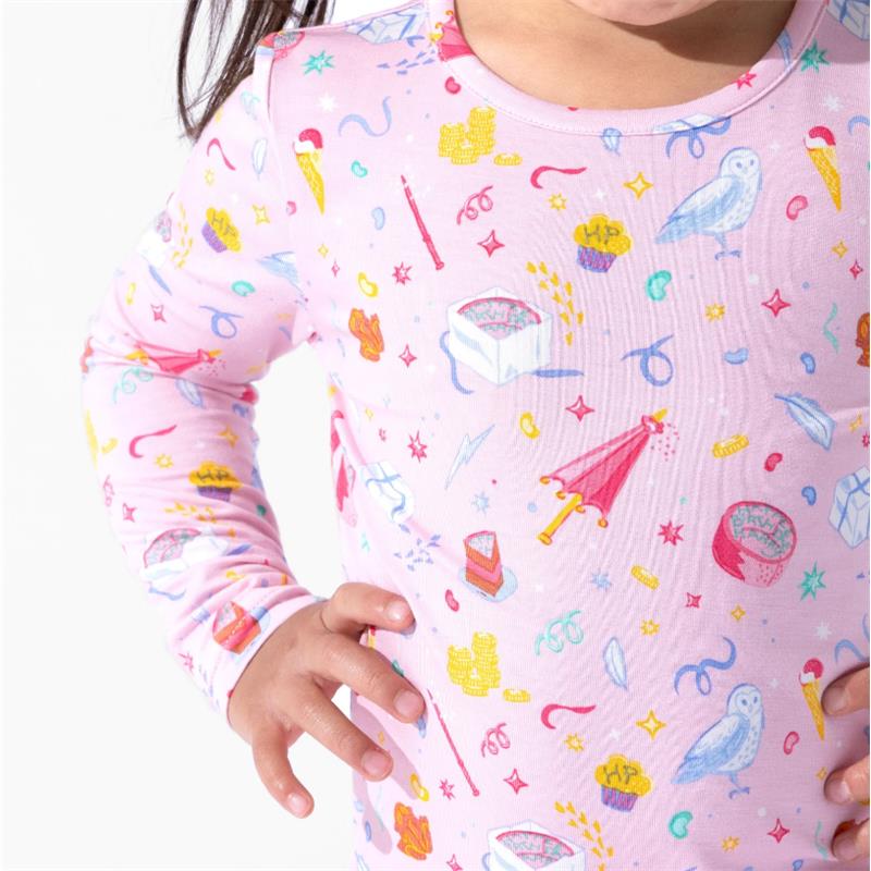Bamboo kids pajamas featuring a pink pattern with Harry Potter-themed icons, including wands, owls, and colorful sweets.