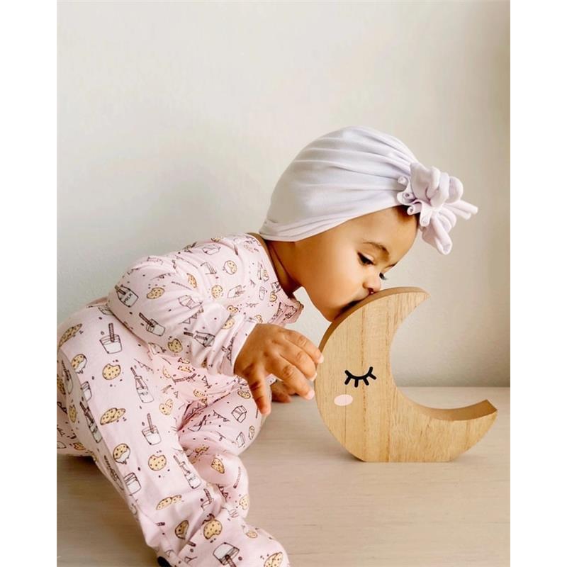 Bambini in rosa con pigiama di bambù Bellabu Bear, mentre bacia una decorazione a forma di luna in legno.