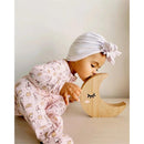 Bambini in rosa con pigiama di bambù Bellabu Bear, mentre bacia una decorazione a forma di luna in legno.