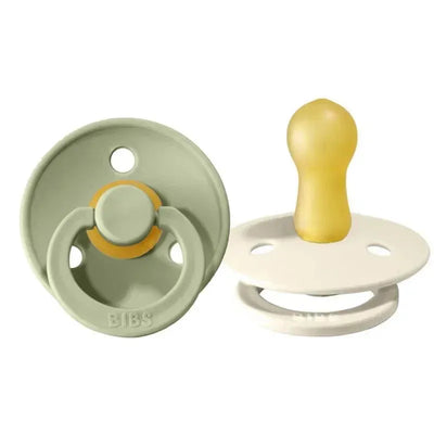 Two BIBS natural rubber baby pacifiers in sage green and ivory, designed for ages 0-6 months.