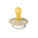 BIBS 2Pk Vanilla GLOW/Dark Oak GLOW rubber baby pacifier for 0 to 6 months, featuring a soft, yellow nipple and beige base.