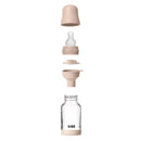 4Oz silicone baby bottle by Bibs, featuring a blush bumper, cap, and nipple, showcasing its layered components.