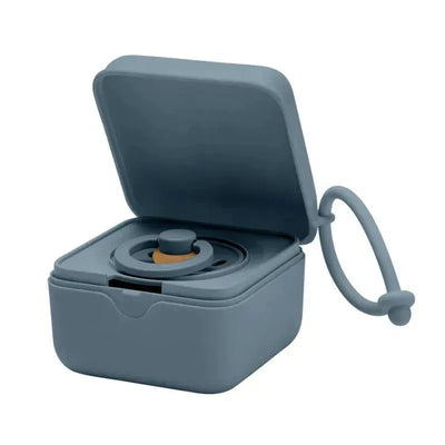 BIBS pacifier box in petrol color, open, showcasing a pacifier inside with a loop for attachment.