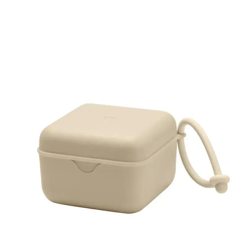 Vanilla-colored pacifier box with a secure closure and an attached loop for easy carrying.