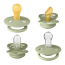 Natural rubber and silicone pacifiers in sage color, designed for infants 0-6 months, displaying various nipple shapes.
