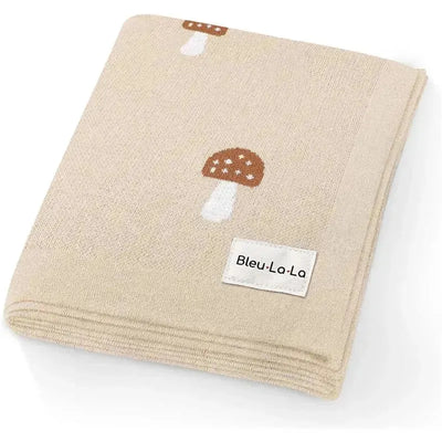 Luxury cotton baby blanket from Bleu La La featuring mushroom patterns on a beige background.