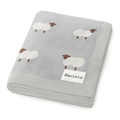 Luxury cotton baby swaddle blanket in ivory with sheep patterns and a Bleu La La label. Soft and cozy for newborns.