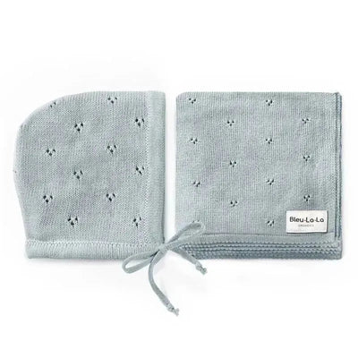 Luxury organic blanket and bonnet hat set in blue, made from 100% organic cotton, featuring a textured pattern and logo.