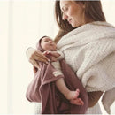 Luxury organic cotton blanket and bonnet hat set in blue, wrapped around a baby held by a smiling woman.