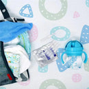 Camilia Teething Relief product packaging next to a blue baby sippy cup and baby care items on a patterned background.