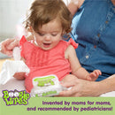 Toddler in a coral shirt excitedly reaching for Boogie Wipes, a pack of saline nose wipes, while being assisted by an adult.