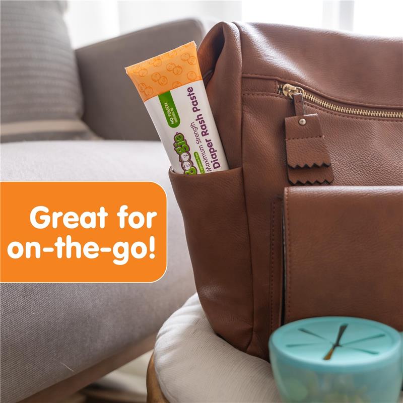 Boogie Wipes Maximum Strength Diaper Rash Paste is partially visible in a pocket of a brown leather bag, with text highlighting its convenience for travel.