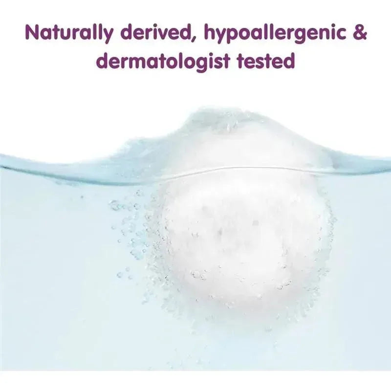 Bath bomb dissolving in water, labeled as naturally derived, hypoallergenic, and dermatologist tested.