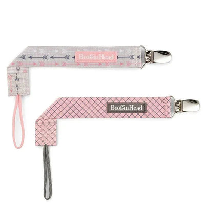 Two Booginhead pacifier clips in pink arrow and pink diamond patterns, featuring silver clips and loops for easy attachment.