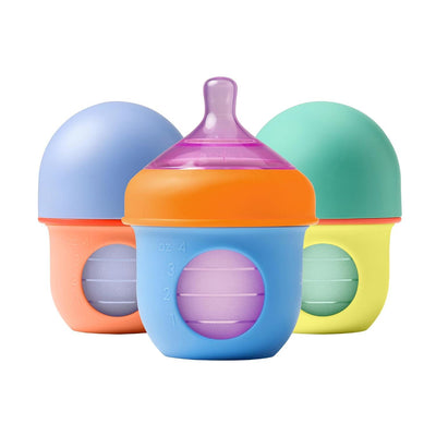 Three colorful Boon Nursh silicone baby bottles (4 oz) in orange, blue, and green, designed for infant feeding.