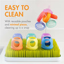 Boon 3Pk Nursh Silicone Baby Bottles with colorful caps on a grass-like drying rack, highlighting easy cleaning features.