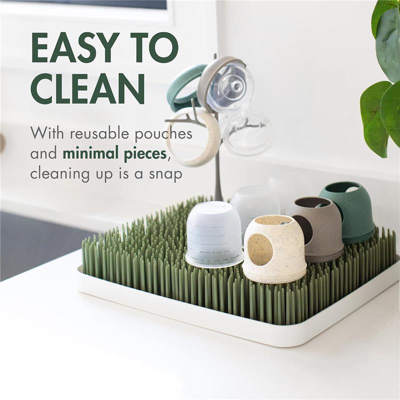 Boon 4 oz Nursh silicone baby bottles in green speckle on a drying rack, featuring reusable pouches and easy cleaning.