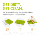 Countertop drying rack with green grass-like raises for drying bottles and utensils, accompanied by care instructions.