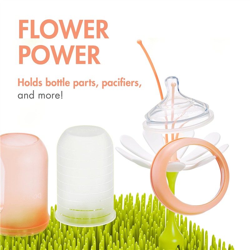 Boon LAWN drying rack features a flower design holding bottle parts and pacifiers, with an orange and green color scheme.