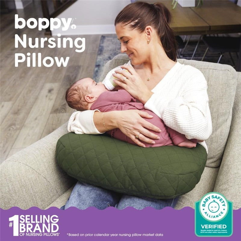 Boppy Nursing Pillow Luxe in moss quilted fabric supports a mother feeding her baby with a bottle.
