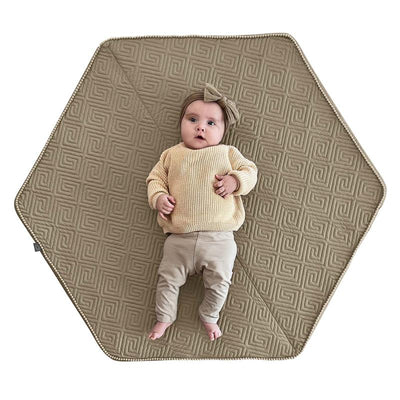 Boppy Foam Play Mat in Natural-Maze Tan with a baby lying on it, featuring a non-skid backing for safe play.