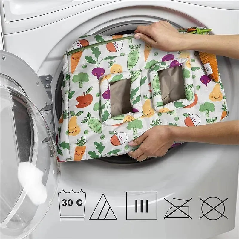 Boppy Farmers Market Shopping Cart & High Chair Cove being placed into a washing machine, showcasing a colorful vegetable pattern.
