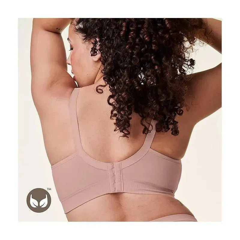 Seamless nursing bra in soft pink, showing adjustable straps and a hook-and-eye closure at the back, modeled by a woman.