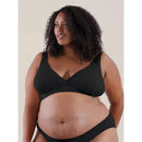 Black Bravado Restore Bra in sustainable yarns, worn by a smiling model with curly hair, showcasing comfort and style.