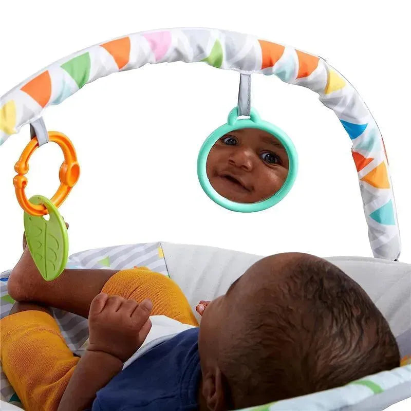Baby in a Bright Starts bouncer, reaching for colorful hanging toys and looking at their reflection in a mirror.