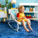 Toddler happily seated in a Bright Starts Disney Baby Mickey Mouse rocker, wearing a red shirt and yellow overalls, on a blue rug.