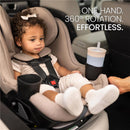 Britax Galaxy360 Slim Rotating Convertible Car Seat in Teak, featuring a child securely strapped in and a cup holder with a drink.