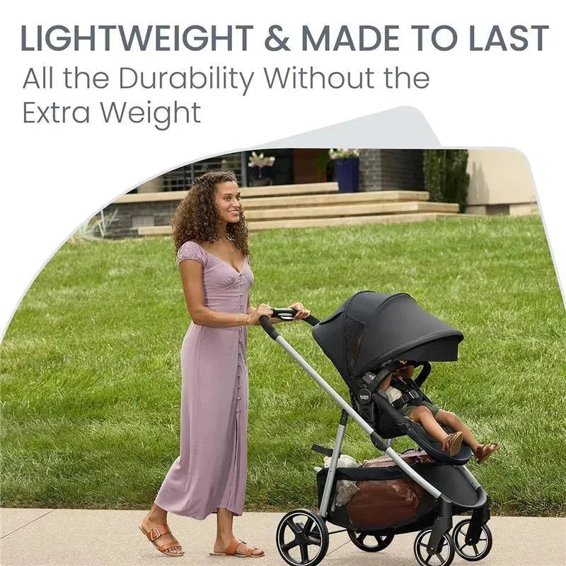 Lightweight Britax Grove Modular Stroller being pushed by a woman in a purple dress, with a child seated inside.