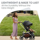 Lightweight Britax Grove Modular Stroller being pushed by a woman in a purple dress, with a child seated inside.