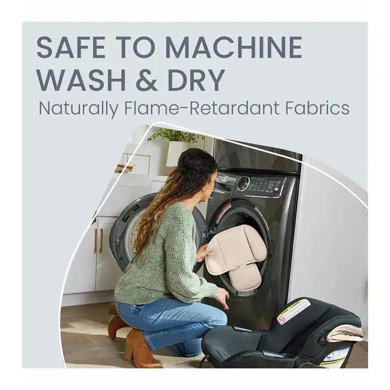 Woman placing a baby car seat insert into a washing machine, highlighting its machine washable features and flame-retardant fabrics.