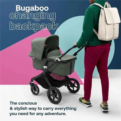 Water-repellent Bugaboo changing backpack in desert taupe, worn by a person beside a stroller, with colorful background text.