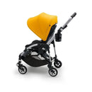 Bugaboo Cup Holder attached to a black stroller with a bright yellow canopy, designed for convenient beverage storage.