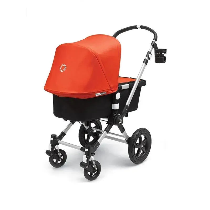 Bugaboo Cup Holder in Black attached to a stroller with a bright orange canopy and a black seat, showcasing its practical design.