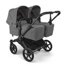 Bugaboo Donkey 6 Complete Stroller in Black/Moon Grey featuring two seats, adjustable canopies, and a spacious storage basket.