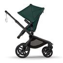 Bugaboo Fox 5 Renew Complete Bassinet and Seat in black and fern green, featuring adjustable seat, large wheels, and a spacious storage basket.