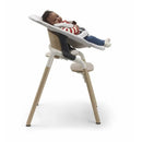 Bugaboo Giraffe Newborn Set in Tornado Grey with a smiling baby reclining in the high chair.