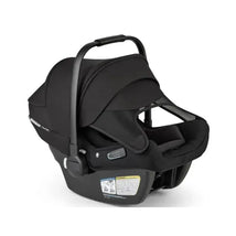 Car seat from Bugaboo - Turtle Air Shield by Nuna, featuring a sleek black design, adjustable handle, and safety labels.