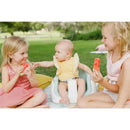 Three children enjoy watermelon slices outdoors; a baby in a taupe Bumbo multi-seat reaches for one slice.