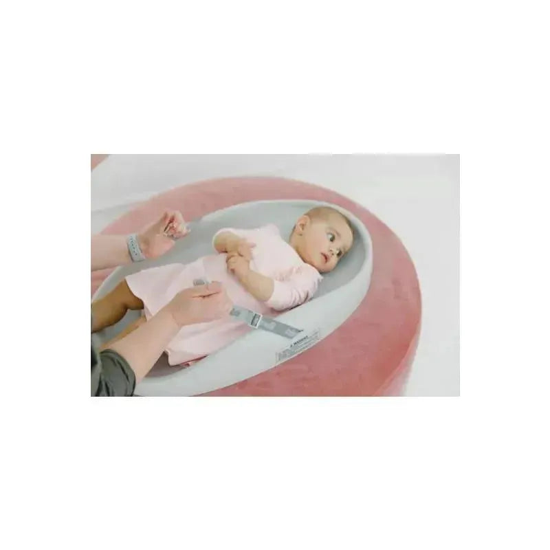 Bumbo changing pad in Cool Grey with a baby wearing a pink outfit, while an adult secures the straps.